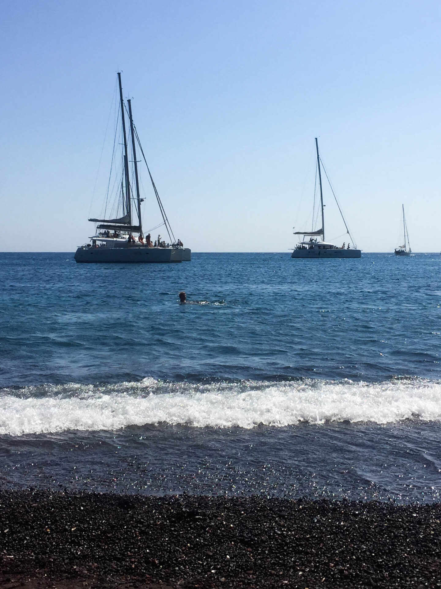 Santorini Red beach sailing boats